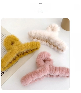 Detailed view of plush faux fur hair claw clips in yellow, beige and pink soft colors