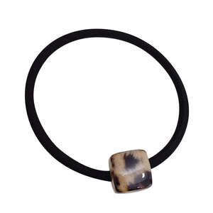 Elastic black hair tie featuring a square leopard print resin charm on white background