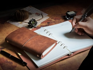 Detail view of brown vintage leather binder with lined pages and retro nautical map background