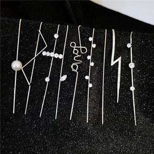 Detailed view of silver zircon ear climbers with love shape and pearls on black velvet