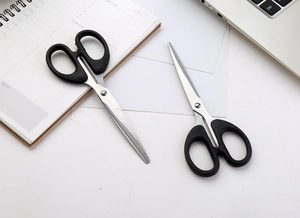 Black ergonomic scissors set for office and home use on a minimalist white desk