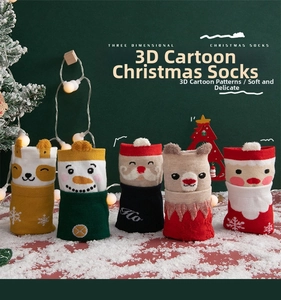 Detail of five 3D cartoon Christmas mid-calf socks with plush ears on a snowy red surface