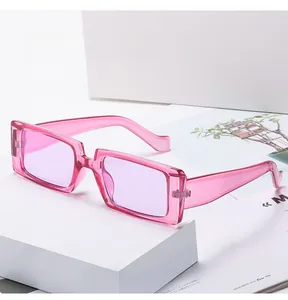 Detailaufnahme der pinkfarbenen transparenten rechteckigen Sonnenbrille auf weißem Podest