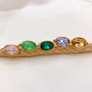Set of five vintage gold rings with colorful oval gemstones on rustic hemp rope