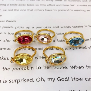 Detail of five-piece oval crystal ring set in red, pink, blue, yellow, and iridescent