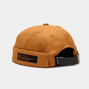 Detail of docker hat showing canvas texture with side woven label and leather back strap