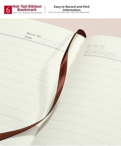 Macro detail of ivory lined notebook paper featuring a deep red silk ribbon bookmark