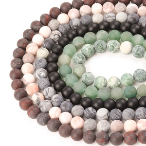 Macro shot of colorful matte frosted stone beads arranged in circular patterns for DIY jewelry