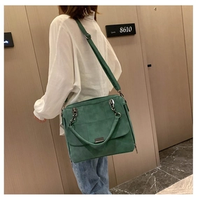Dettaglio borsa Boston in camoscio verde con catena dorata e fibbia in metallo