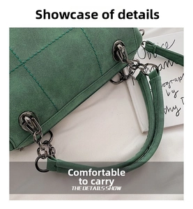 Dettaglio borsa Boston in camoscio verde scuro con cuciture trapuntate e catena in metallo