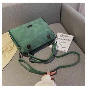 Borsa Boston vintage in pelle scamosciata verde con cuciture trapuntate su divano grigio