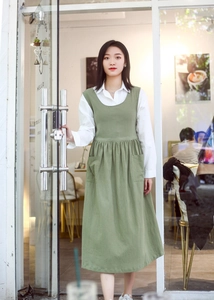 Detail of green plus size cotton apron with side openings and dual front pockets