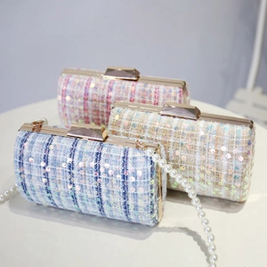 Detail of sequined tweed clutch bags with gold metal frames and pearl chain straps