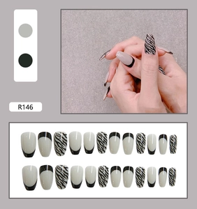 Detailed view of long coffin zebra print press-on nails with minimalist black and white design