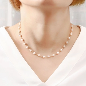 Close-up of elegant oval freshwater pearl necklace with gold metal chain on neck