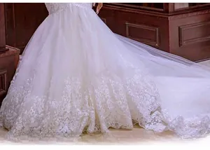 Dettaglio dell'orlo dell'abito da sposa a sirena bianco con pizzo e paillettes