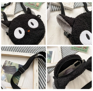 Detail view of the plush black cat crossbody bag showing embroidery and strap
