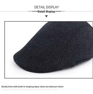 Detail of the firm brim on this grey herringbone newsboy cap with textured wool fabric