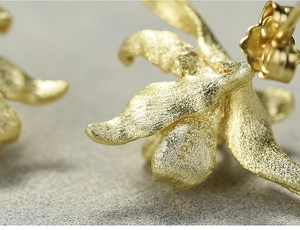 Macro shot of S925 sterling silver stamp and brushed gold flower petal texture