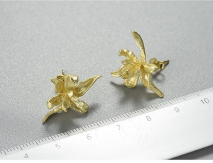 Macro detail of matte gold iris floral earrings showing brushed texture and 20mm scale