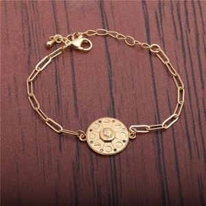 HipHop gold paperclip bracelet with colorful cubic zirconia pendant on wooden background