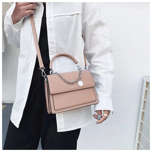 Detail of nude pink faux leather handbag with silver chain and FASHION & BAGS logo