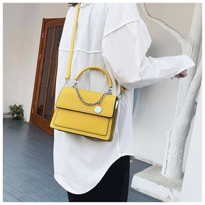 Detail of yellow leather handbag with silver chain and Fashion & Bags text on model