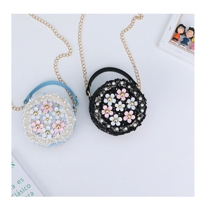 Detail of tweed mini round purses with floral pearls and golden chain straps