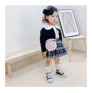 Detail of a navy knit cardigan and white oversized collar blouse for girls