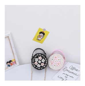 Detail of mini round floral bags in pink and black tweed with pearls and gold chains