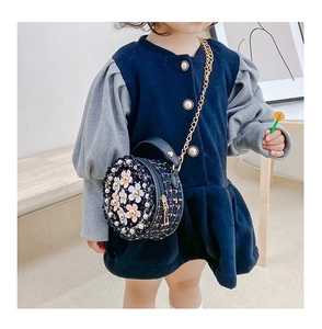 Detail of tweed crossbody bag for girls with 3D floral accents and gold chain strap