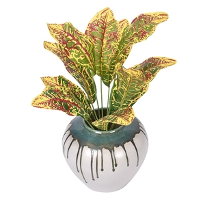 Artificial croton plant in a stylish ceramic vase with colorful realistic foliage