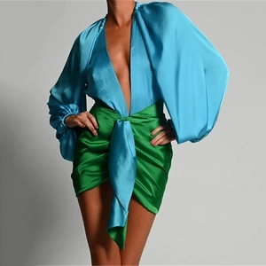 Detail of blue satin puff sleeve bodysuit and green wrap skirt with knot detail