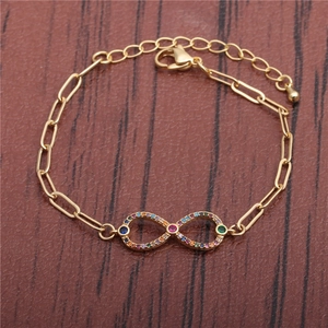 HipHop gold infinity bracelet for women with colorful cubic zirconia on wood background