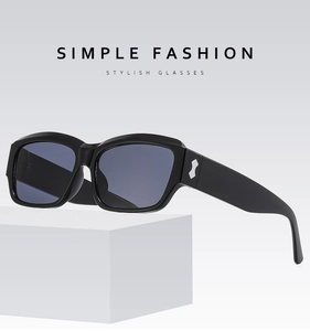 Detail of black rectangular sunglasses with silver geometric accents on temples