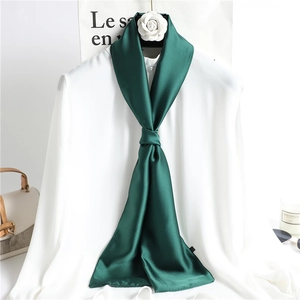 Deep green long skinny silk scarf tied over white shirt collar for elegant styling