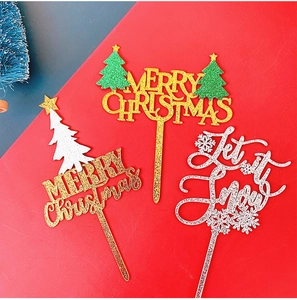 Detailansicht der glitzernden Merry Christmas und Let it Snow Tortenstecker auf Rot