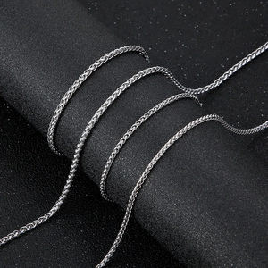 Sleek silver wheat chain necklace for men and women on a black textured background
