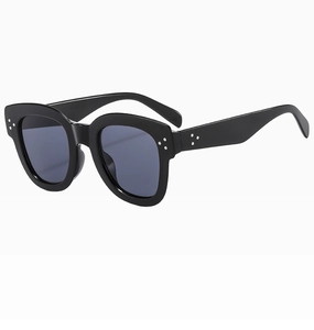 Detail of black bold frame sunglasses with three silver metal triangle studs on edges