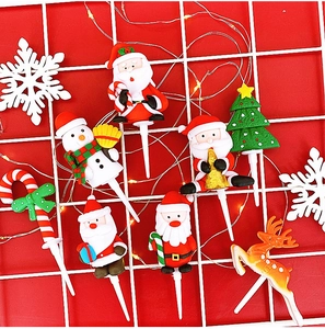 Detailed view of colorful Christmas felt cake toppers with Santa and reindeer on a mesh stand