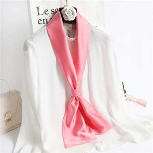 Pink silk skinny scarf tied on a white shirt with sunglasses and a stylish handbag