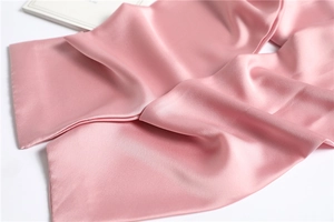 Close-up of pink faux silk scarf showing smooth satin texture and elegant soft luster