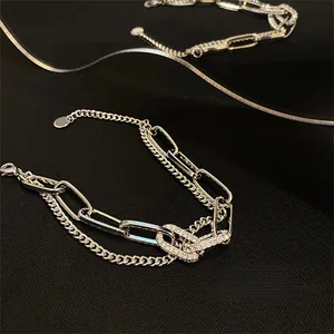 Dettaglio del bracciale a doppia catena con zirconi incastonati e maglie a graffetta