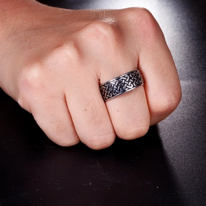 Macro shot of a vintage silver stainless steel ring with Celtic knot pattern on a male hand
