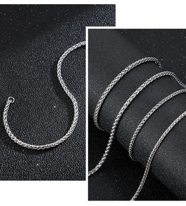 Macro detail of silver wheat chain necklace for men with high polished metal link texture