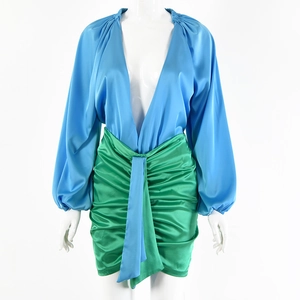 Set sexy con body profondo scollo a V e minigonna in raso verde arricciata su manichino