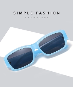 Detail of light blue rectangular sunglasses with UV lenses on a white display stand
