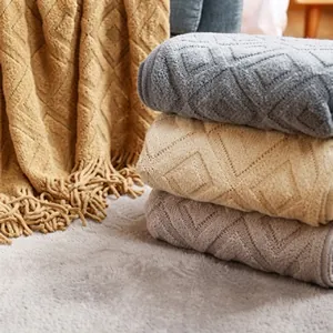 Detailed close-up showing geometric knit texture and soft fringe of the multicolor throw blanket