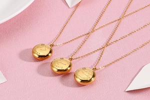 Macro shot of gold stainless steel zodiac necklaces for Libra, Scorpio, and Sagittarius