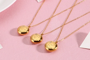 Detail of gold zodiac necklaces with etched constellation names and cubic zirconia